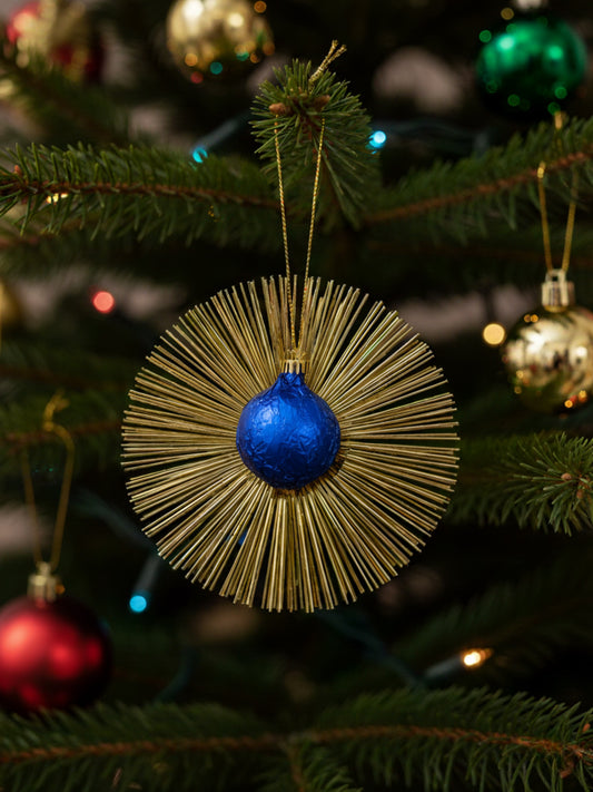 Flimmerstern in der Farbe blau aus Vollmilchschokolade 10 g mit goldenem Lametta und Aufhänger, essbarer Christbaumschmuck, erhältlich in der Dreyer Confiserie in Hameln.