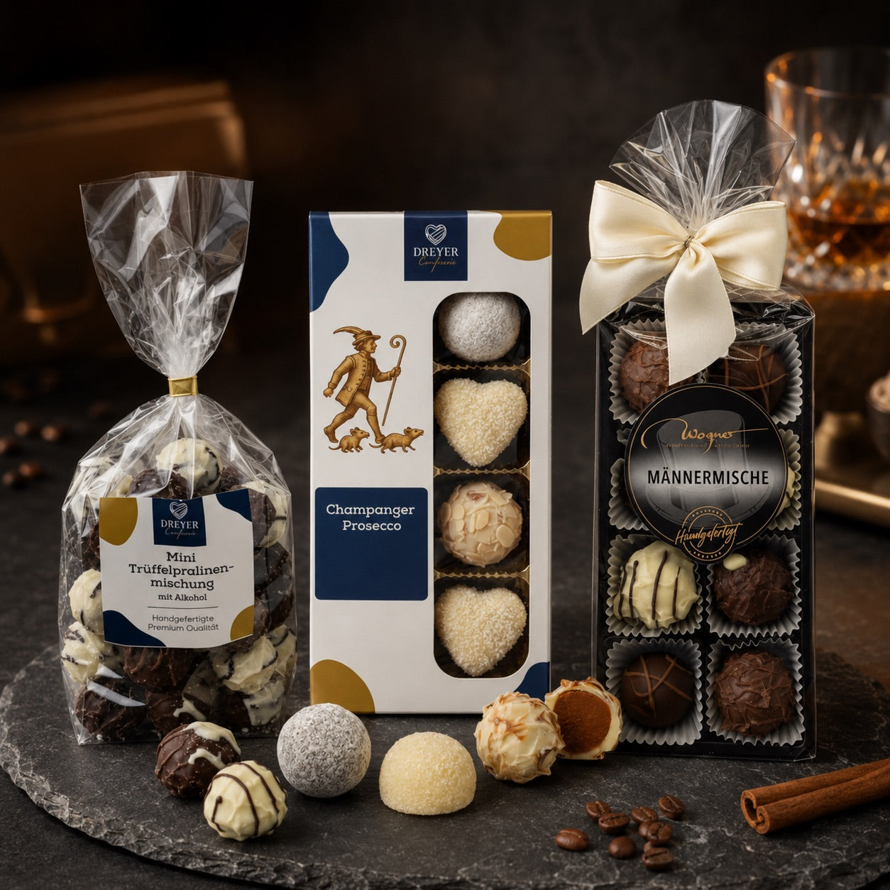Edle Pralinen mit Alkohol auf dunklem Naturstein mit Goldakzenten
