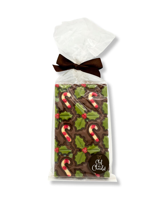 Schokoladentafel „Zuckerstangen“ Vollmilch 150g von Ham Chocolaterie – weihnachtlich dekorierte Vollmilchschokoladentafel mit Zuckerstangen- und Stechpalmenmotiven, erhältlich in der Dreyer Confiserie in der Rattenfängerstadt Hameln.